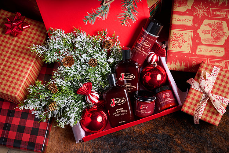 Bottles and jars of boot leather cleaner in a box surrounded by wrapped Chirstmas presents.